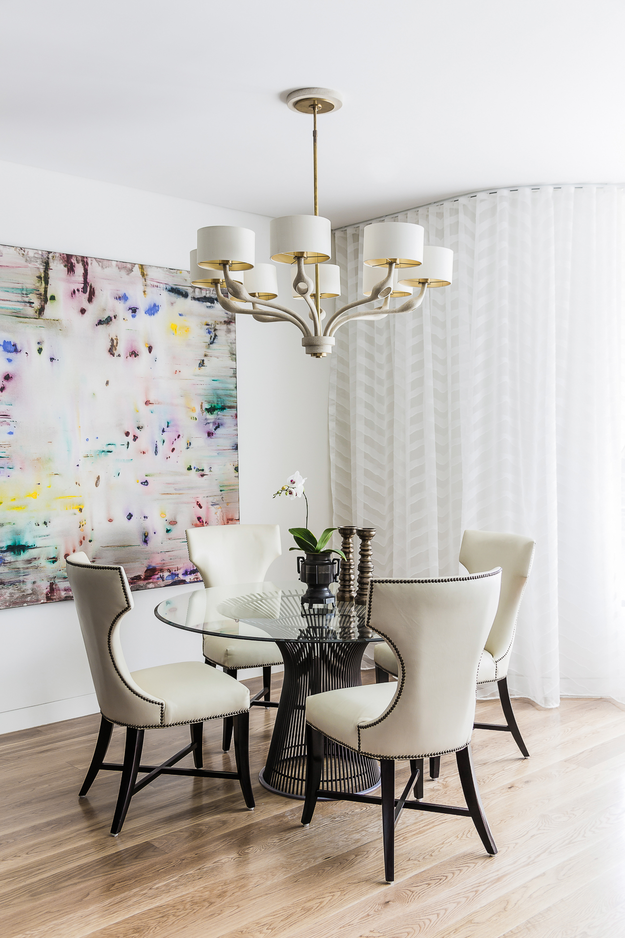 White dining room with sheer curtains, art by Julie Harris and chandelier by Sydney interior designers, Brendan Wong Design