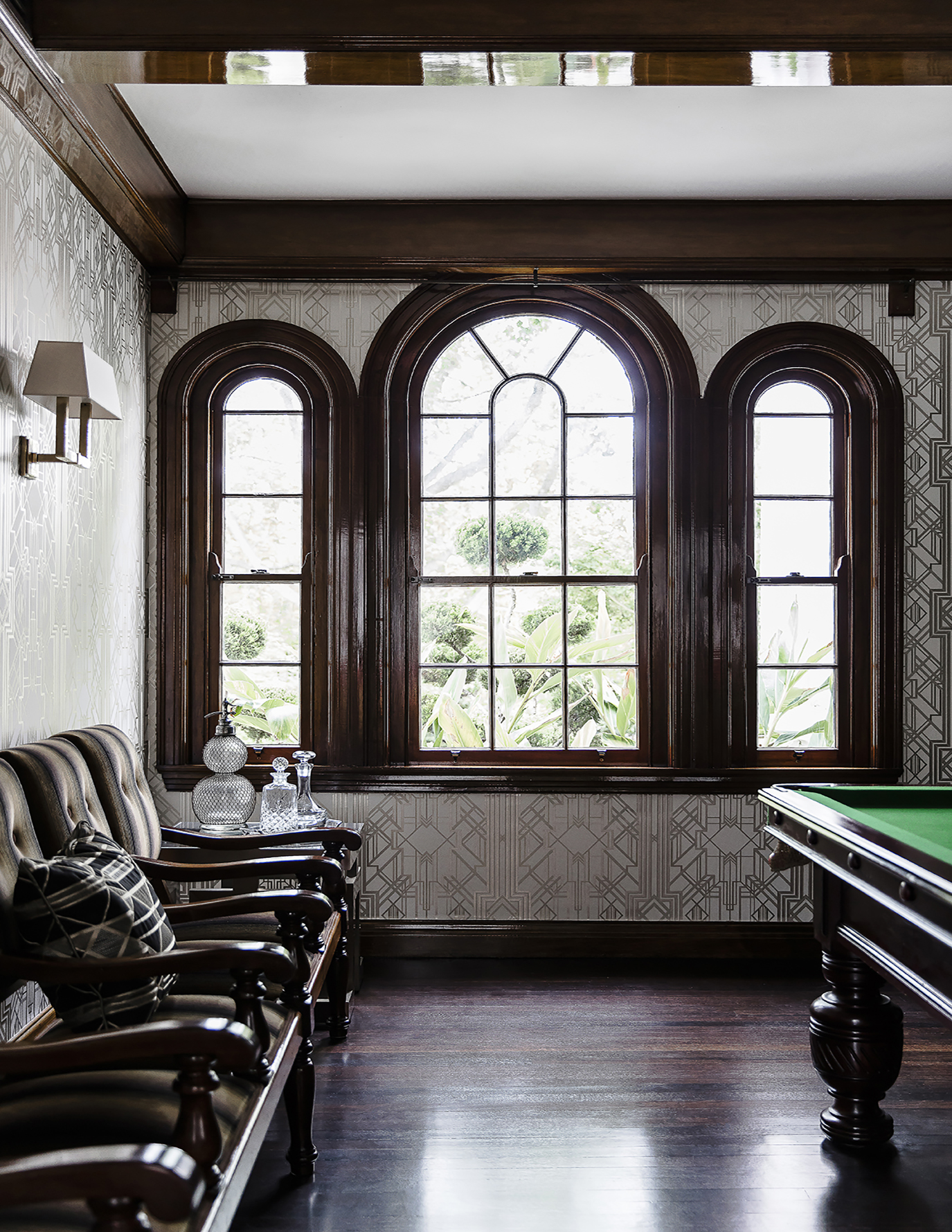 Billiard room with arch windows and brown leather armchairs by Sydney interior designers, Brendan Wong Design