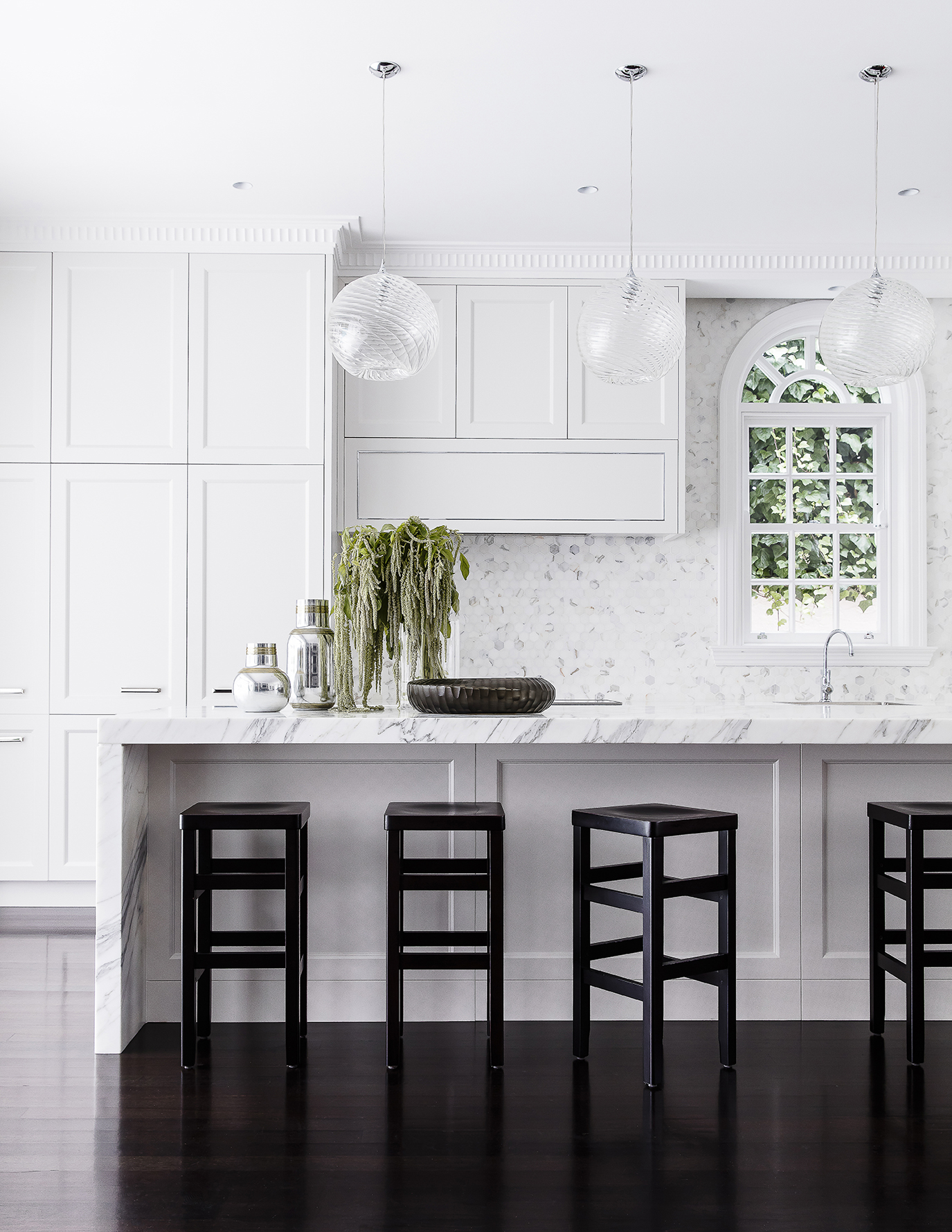 White marble kitchen renovation with arch window and black barstools by Sydney interior designers, Brendan Wong Design