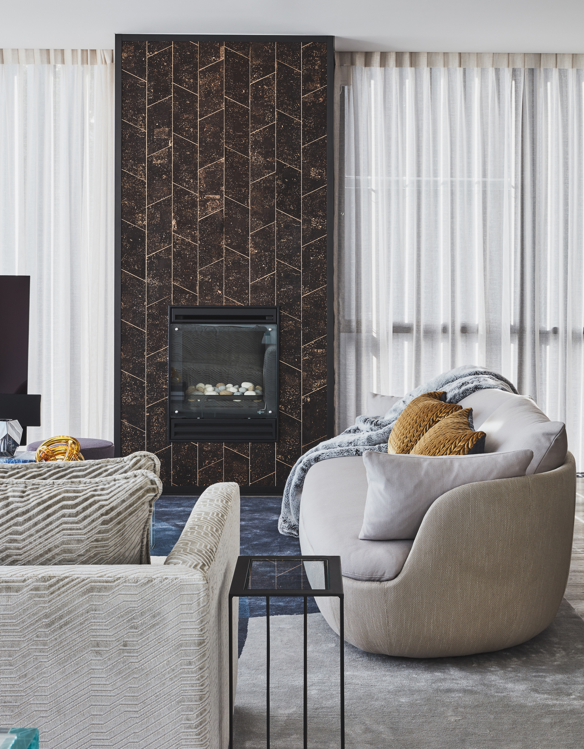 Oceanfront penthouse living room with Moooi sofa and Phillip Jeffries wallpaper clad fireplace by Sydney interior designers