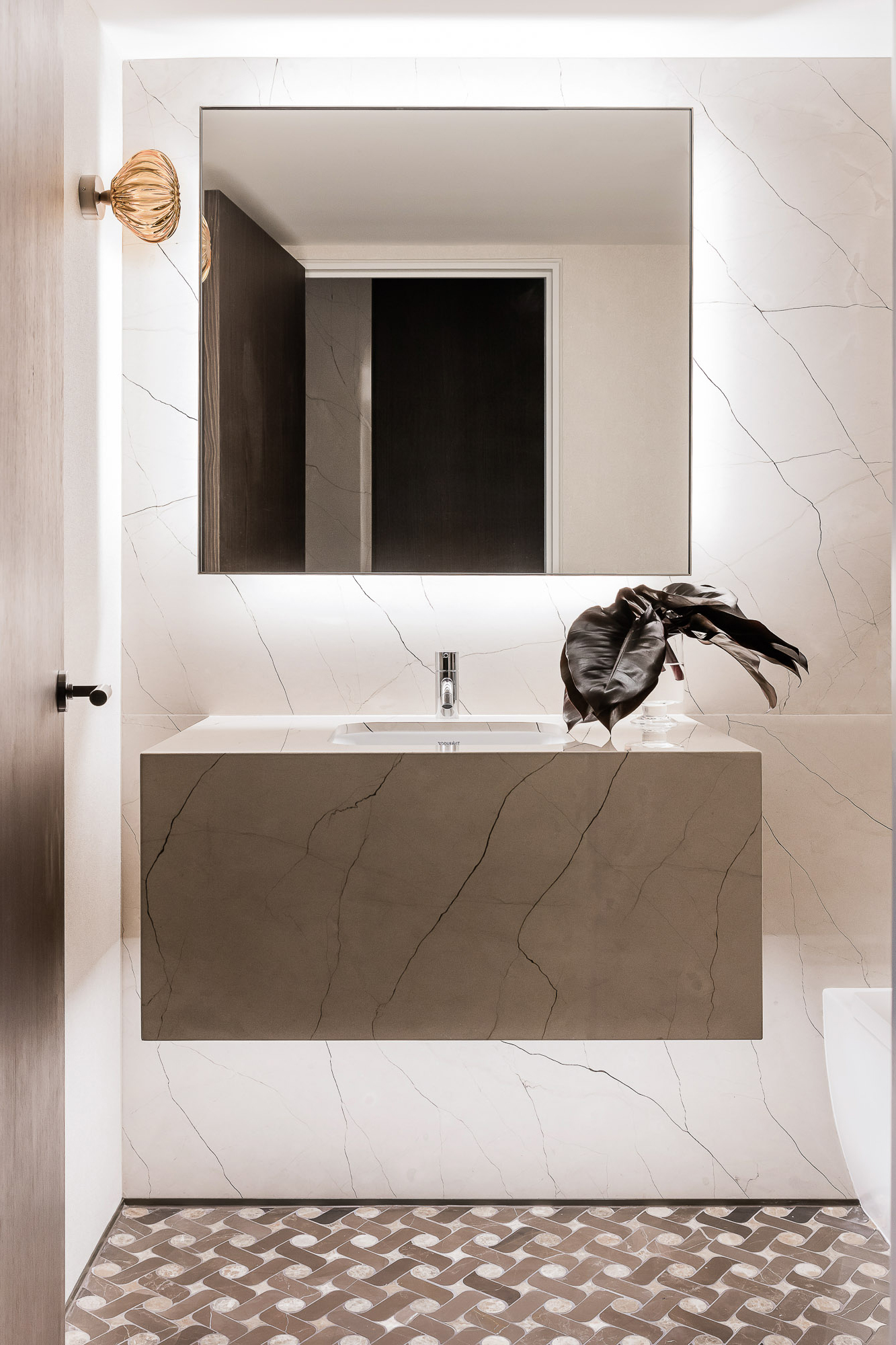 Powder room marble bathroom design with pattern tile floor and wall light by Sydney interior designers, Brendan Wong Design
