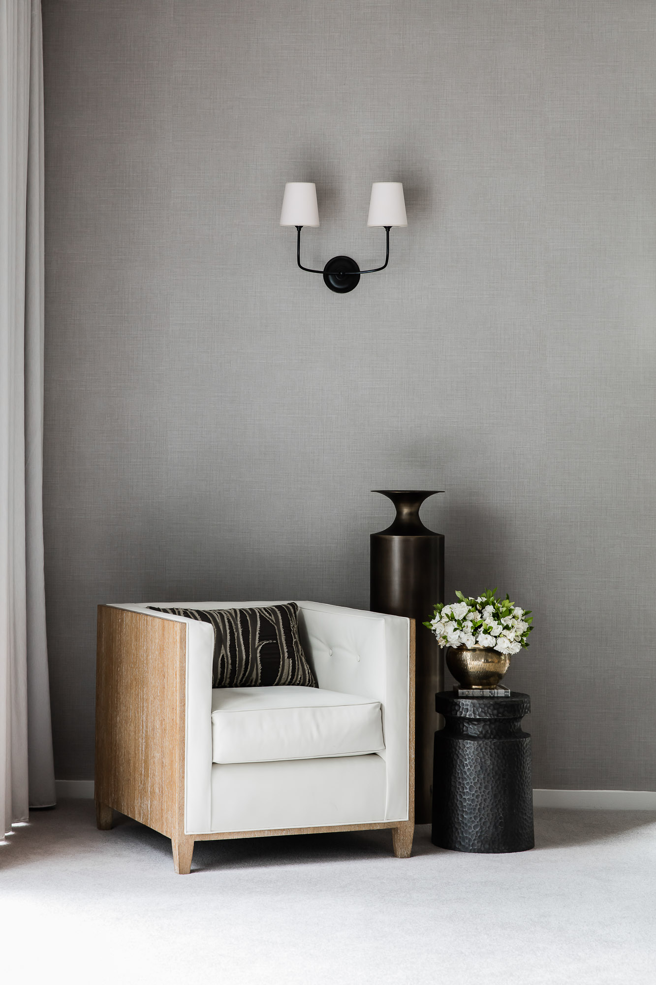 Bedroom with Coco Republic armchair, double wall sconce and bronze vase by Sydney interior designers, Brendan Wong Design