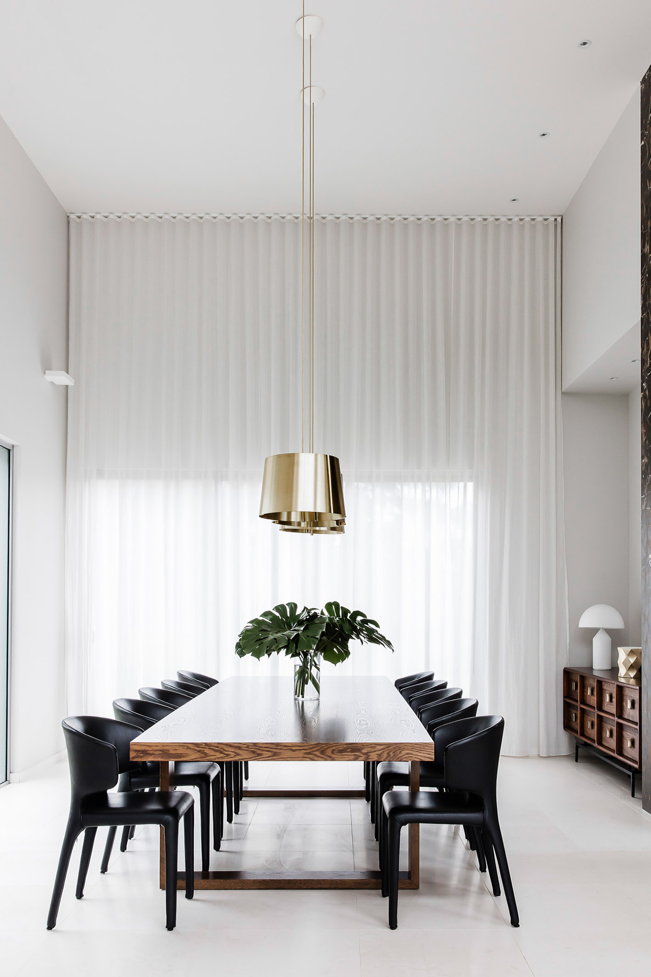 Dining room design with large timber dining table and black leather chairs by Sydney interior designers, Brendan Wong Design