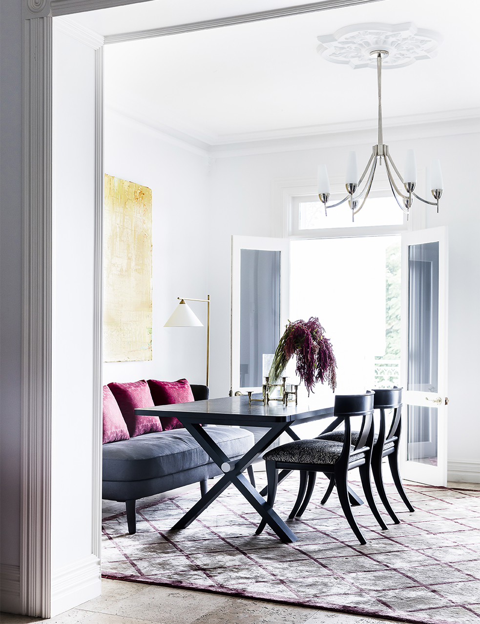 Dining Room By Brendan Wong Design with pink cushions, black table and grey banket style sofa.