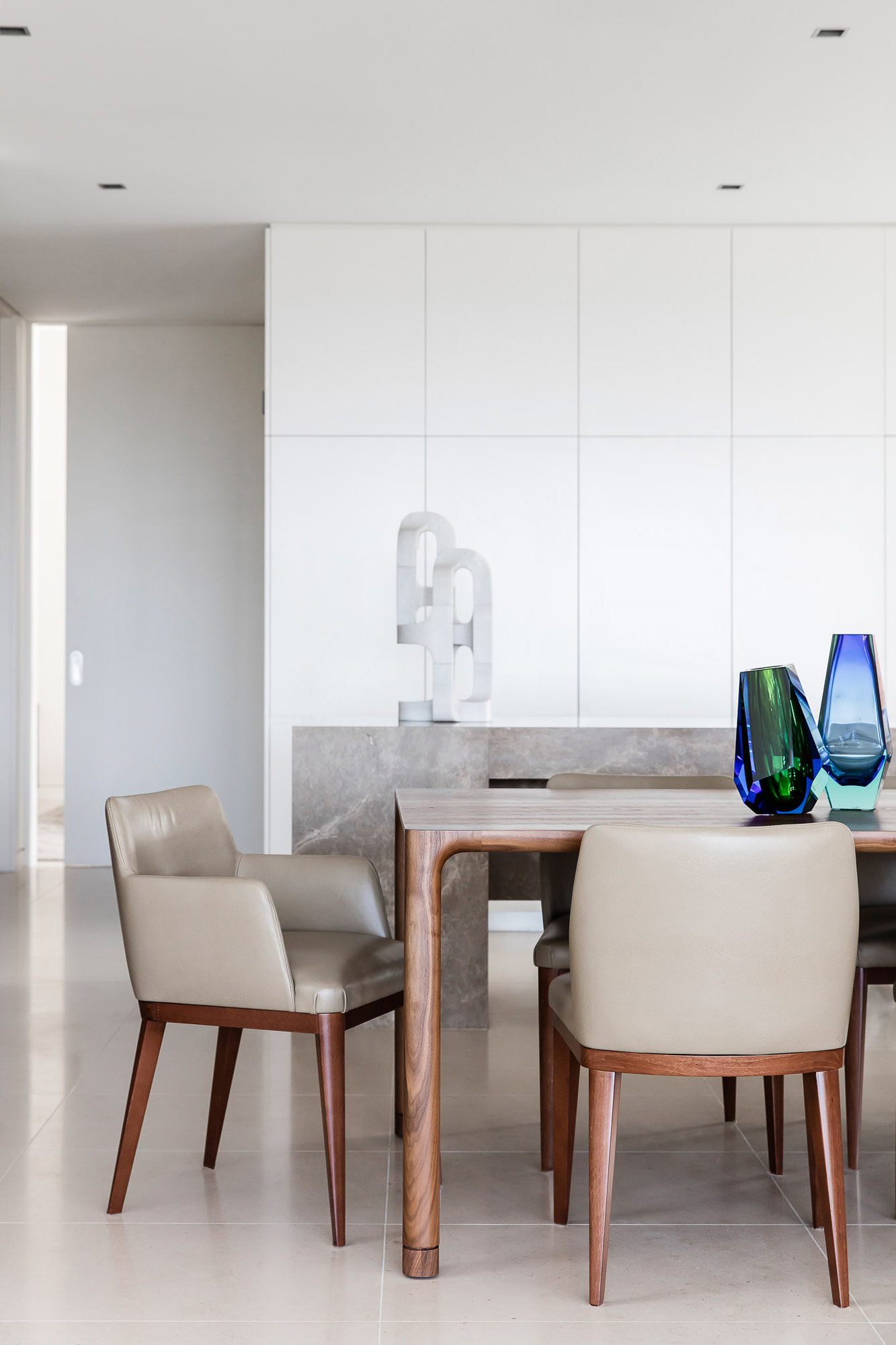 Dining room design with timber table, leather chairs and Stephen Ormandy marble sculpture, by Sydney interior designers