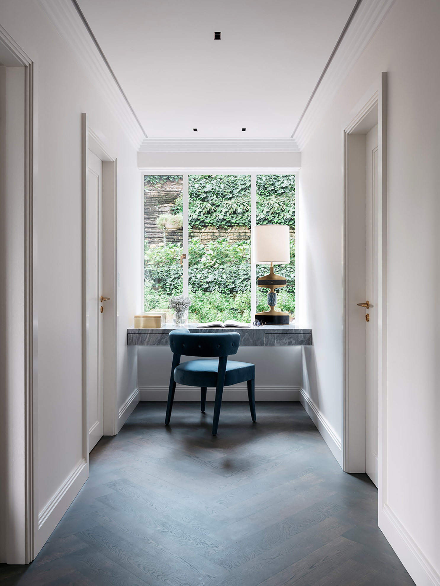 Hallway renovation with blue velvet chair and floating marble study desk by Sydney interior designers, Brendan Wong Design