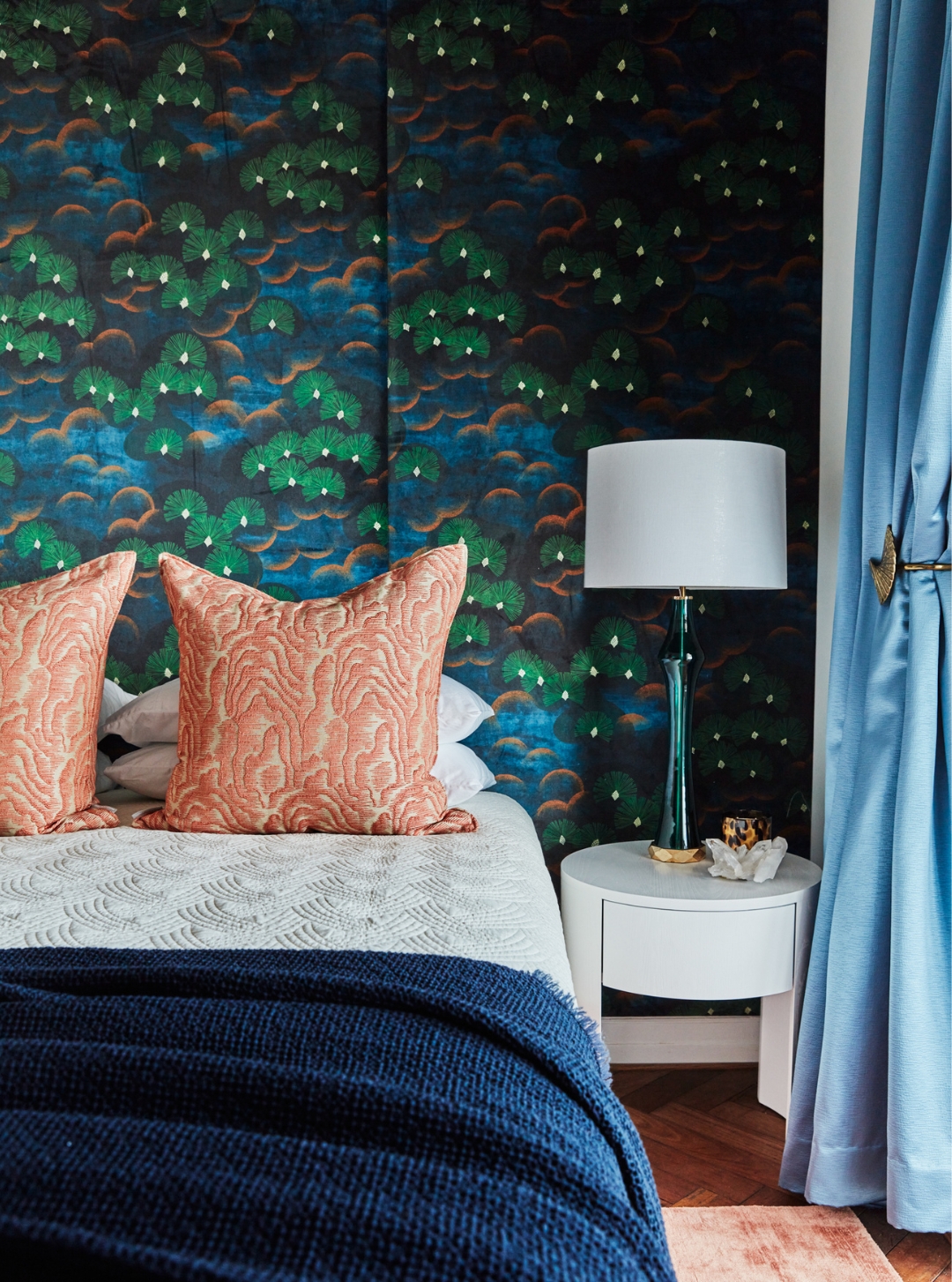 Vibrant bedroom with custom upholstered bed, abstract patterned wallpaper, and luxe coral and navy styling details by Brendan Wong Design in Elizabeth Bay.